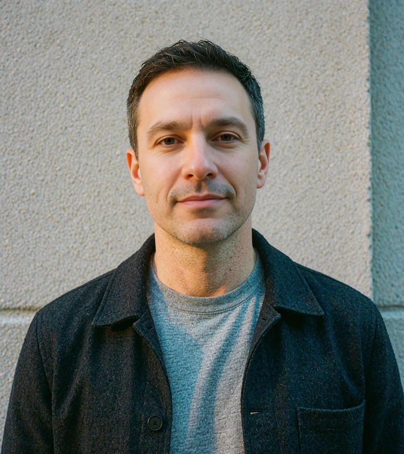Man in his early forties in a charcoal jacket on a city sidewalk, discreet dating app reader profile, elvori review